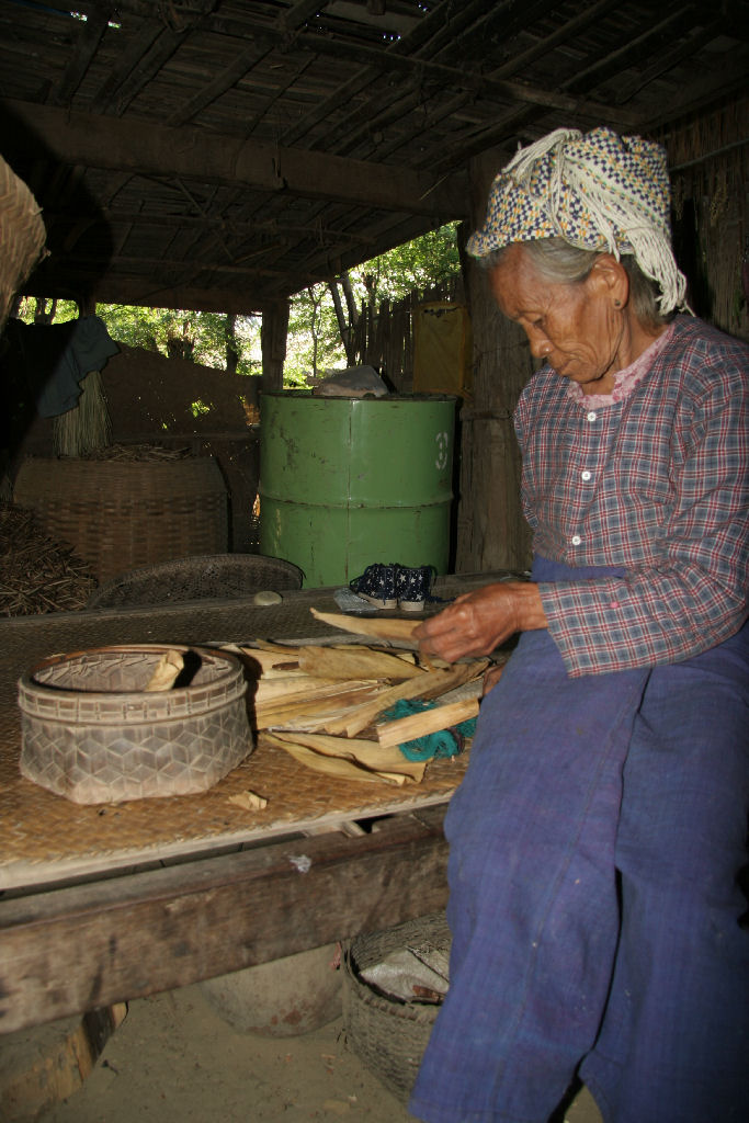 Myanmar - Old woman making a cigar