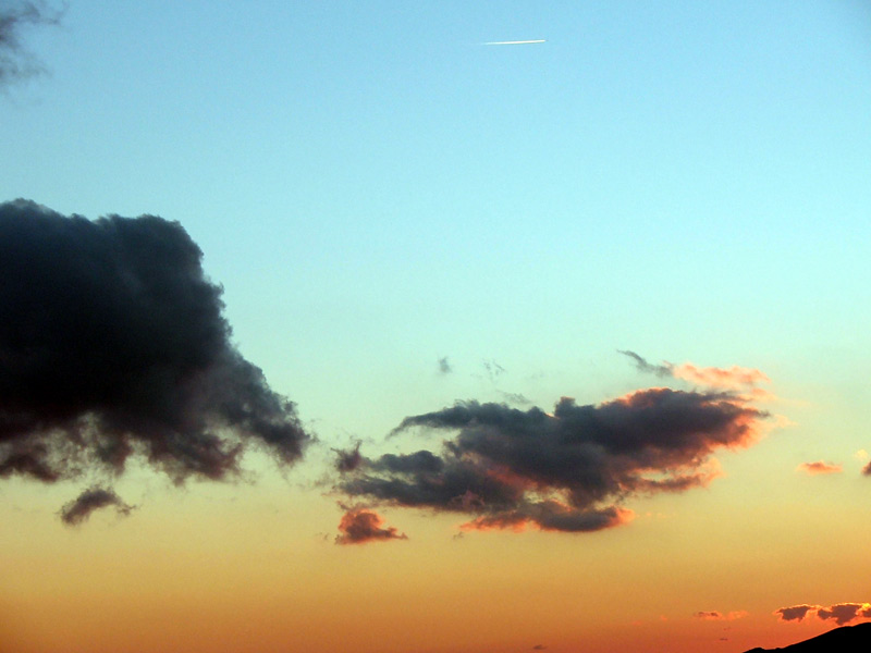 Nuvola con sullo sfondo una scia di un'aereo