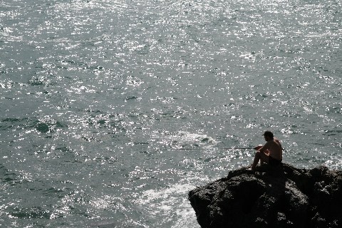 Il pescatore nel mare che luccica