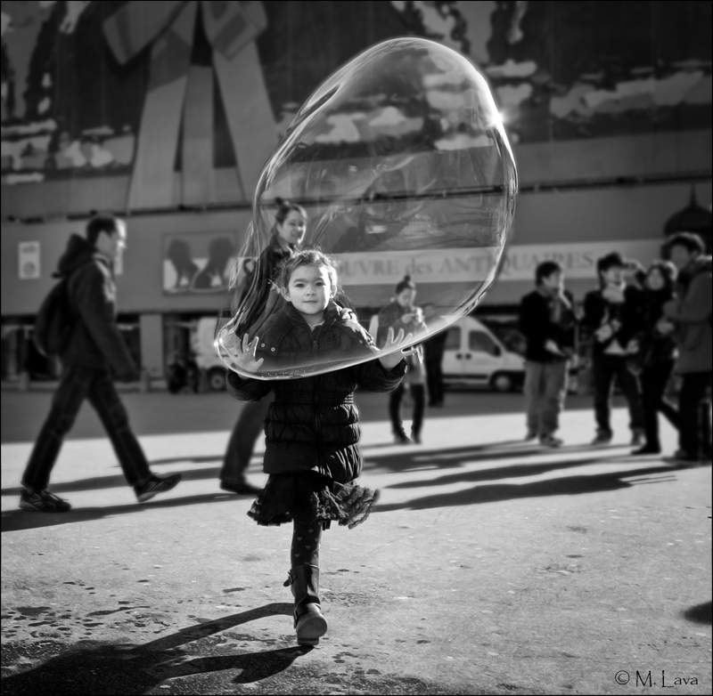Child playing with huge bubble