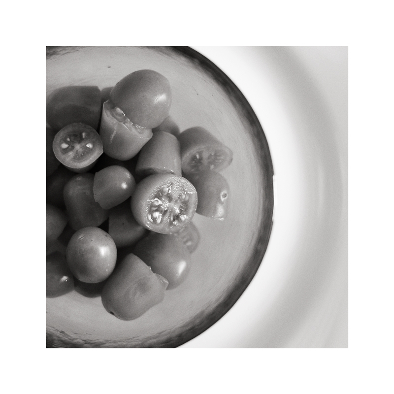 pomodorini in tazza rossa su piatto bianco