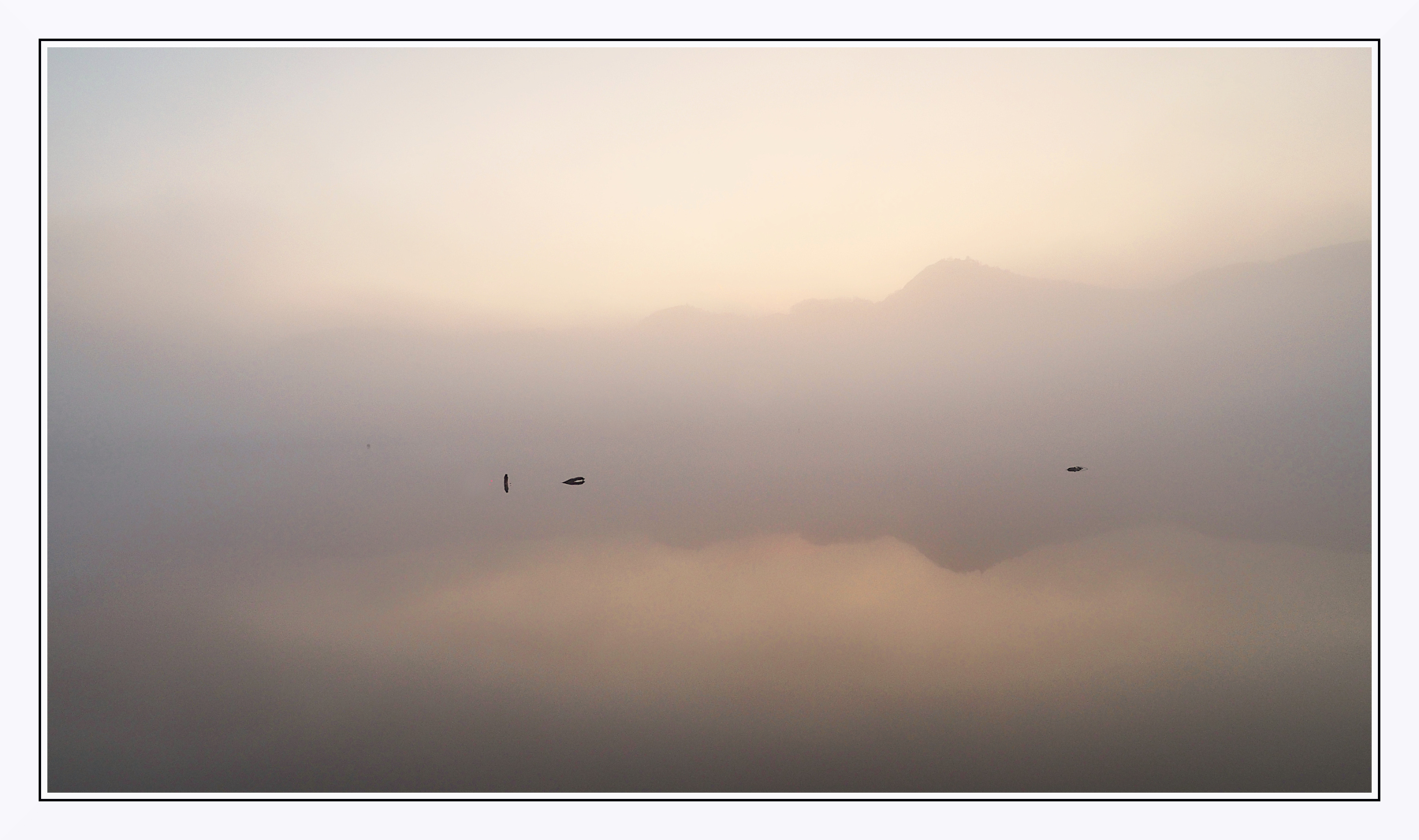 Prime luci sul lago nebbioso