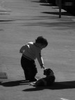 Ero fuori dalla porta del negozio, quando ho notato il bambino e il cane. Sono andato subito a prendere la macchina e ho scattato un po' di foto. Questa � la pi� bella. L'originale � a colori, lo poi portata in Photoshop, aumentato i livelli di rosso e portata in bianco e nero. Il risultato � questo ^^
